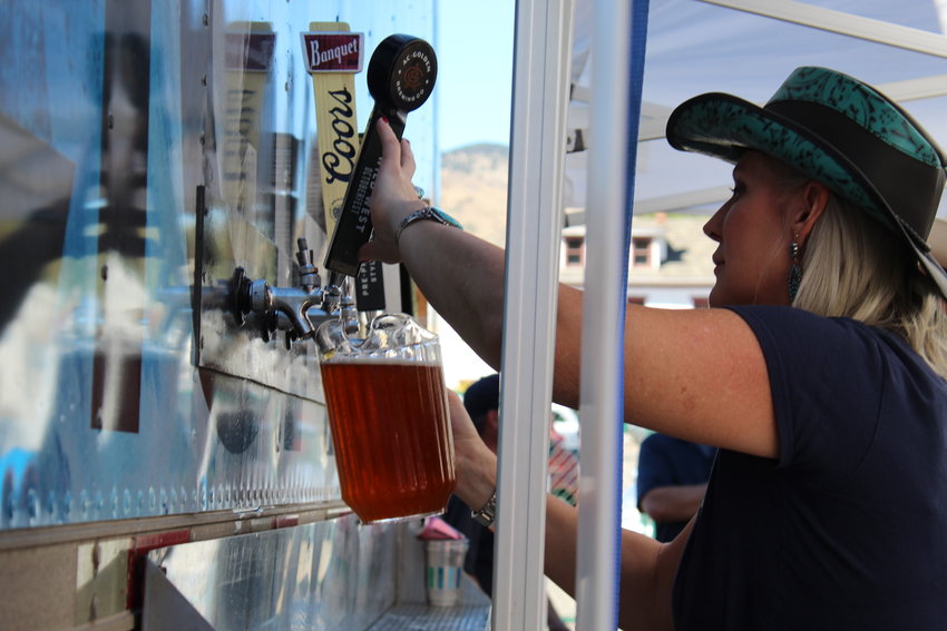 Traci Lacey, a Golden Civic Foundation staff member, pours beer at the inaugural Wild West Oktoberfest Sept. 24 in downtown Golden. Golden Civic Foundation received proceeds from the event, which was organized by YoColorado.